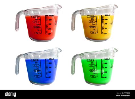 Four Measuring Jugs Filled With Different Coloured Liquids Photographed