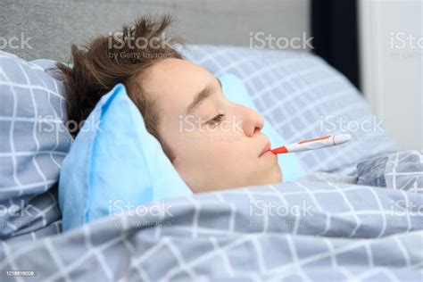 Sick Child Boy Lying In Bed With A Fever Resting Stock Photo Download