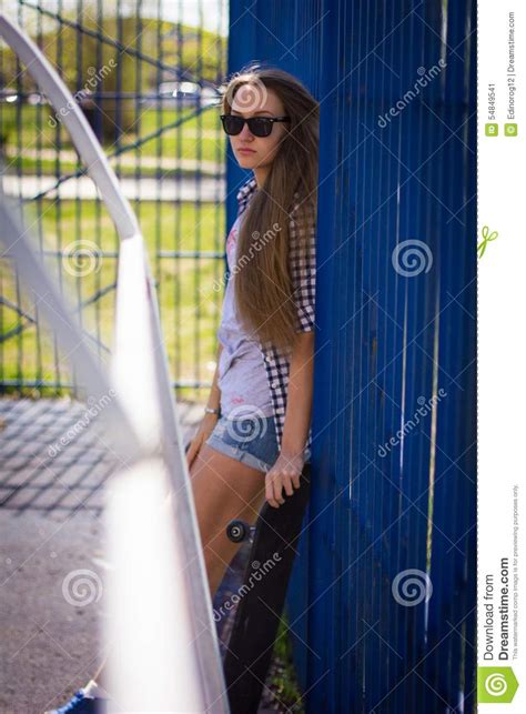 Cute Girl In Shorts With A Skateboard On The Playground Stock Image