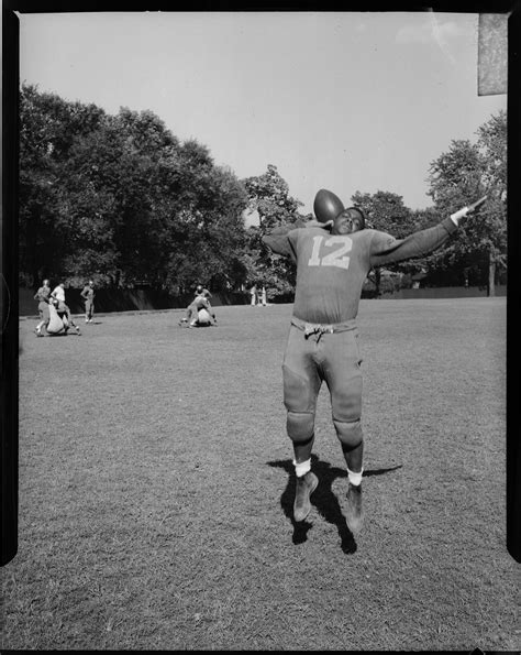 Football Player No 12 Jumping Up With Arms Stretched Outward On