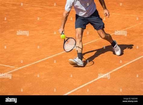 Male Tennis Player In Action On The Clay Court On A Sunny Day Stock