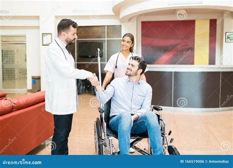 Man Greeting Goodbye To Doctors At Hospital Lobby Stock Photo Image