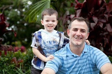 Smiling Little Boy Son With Arm Around Father Outdoors Stock Photo