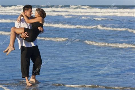 Man Carrying Woman In Romantic Embrace On Beach — Stock Photo © Dmbaker