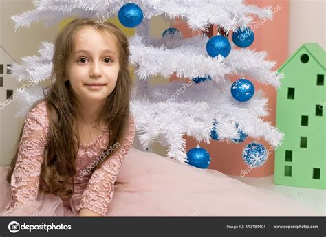 Preteen fille posant devant l arbre de Noël blanc décoré image libre de