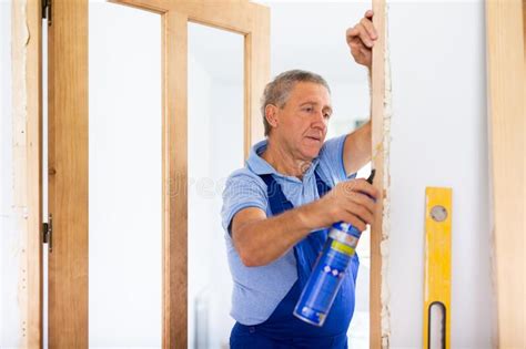 Male Professional Door Installer Fills Gaps With Mounting Foam Stock