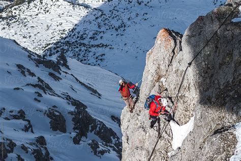 Two Mountain Climbers Rappeling And Fixing Ropes On A Mountain By