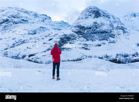 Tourist Looking At The Snow Covered Mountains Of The Three Sisters From
