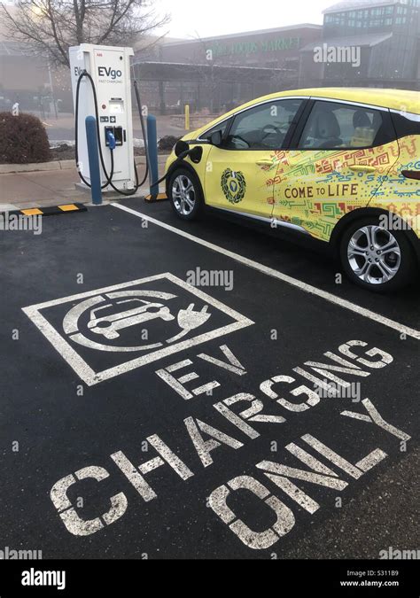 An Electric Chevy Bolt Charges At An Ev Charging Station Outside A