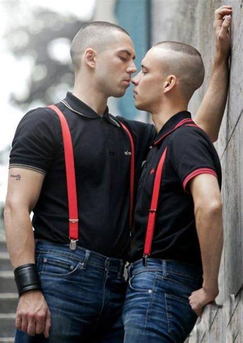 Two Men Standing Next To Each Other With Suspenders On And One Man