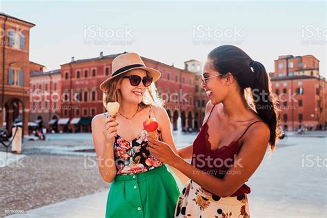 Two Cheerful Young Women Eating Ice Cream And Having Fun On A Town Stock Image Everypixel