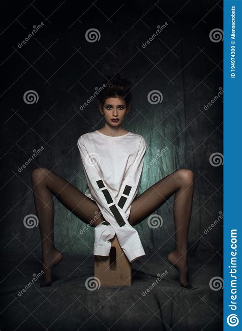 A Girl With Long Legs In Black Tights And A White