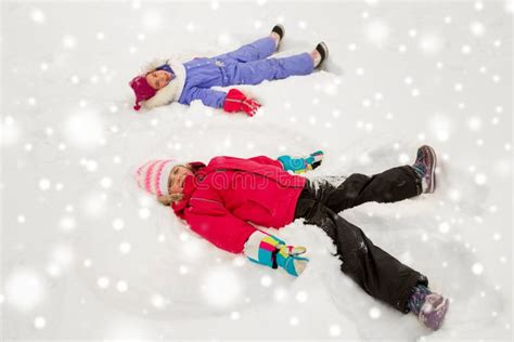 Happy Little Girls Making Snow Angels In Winter Stock Photo Image Of