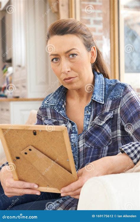 Unhappy Mature Woman Looking At Photograph In Frame Stock Photo Image