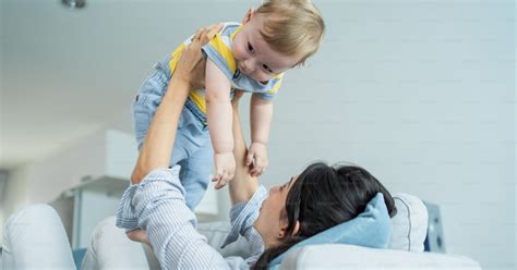 Foto Mamá Amorosa Caucásica Juega Con Un Niño En El Sofá De La Sala De