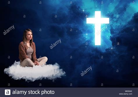 Caucasian Woman Sitting On A White Fluffy Cloud Looking At A Big Bright Blue Glowing Cross