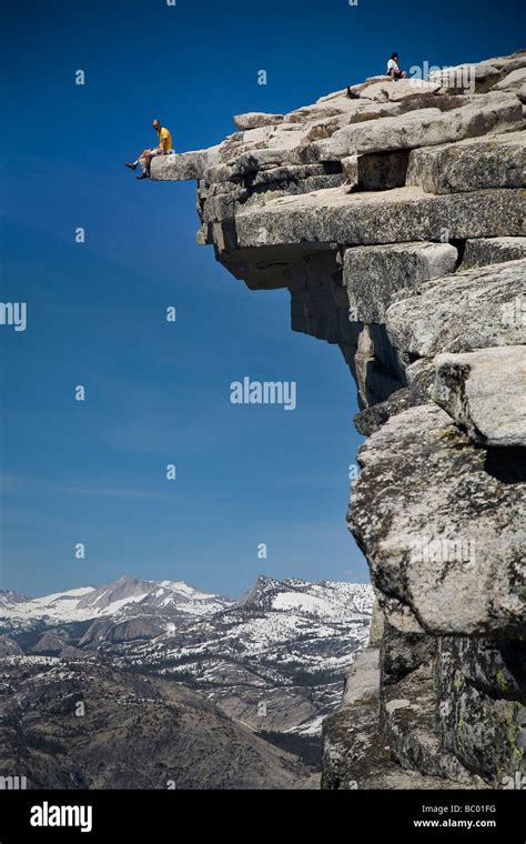 Climber Sits On The Edge Of The Diving Board Atop Half Dome In The