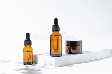 Set Of Amber Glass Cosmetic Bottles On Baige Background Dropper Bottle