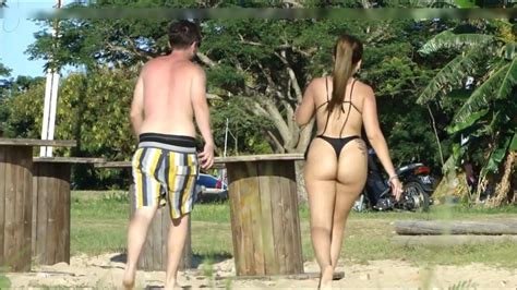 Frau mit einem tollen Arsch trägt einen Tanga und wird am Strand gefilmt