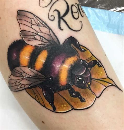 A Close Up Of A Tattoo With A Bee On It