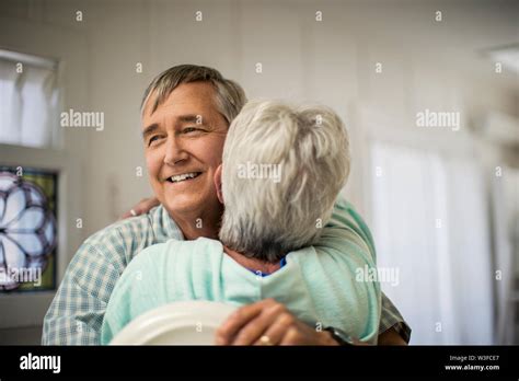 Affectionate Mature Couple Share A Spontaneous Hug As They Finish