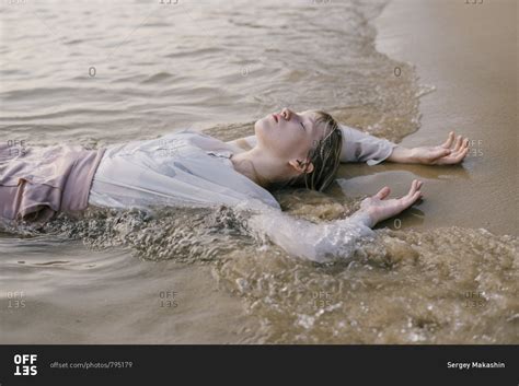 Beautiful Babe Girl Is Lying Sand In The Sea And Closing Her Eyes In Vietnam Stock Photo OFFSET