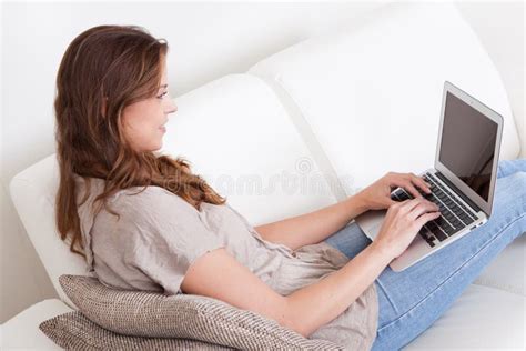 Woman Relaxing On Sofa Using Laptop Stock Photo Image Of Amusement