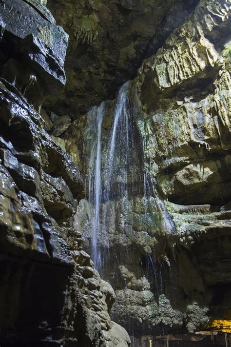 Geological Rock Formations And Waterfall In An Underground Cave Stock