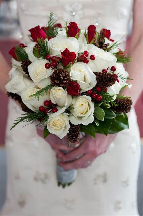 Bride Carrying White Rose Bouquet With Pine Cones And Holly For Winter