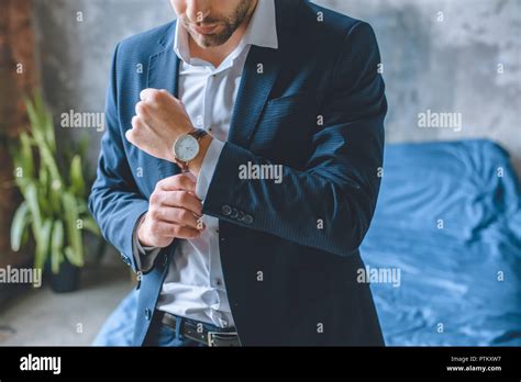 Cropped Image Of Businessman In Suit Putting On Wristwatch In Bedroom
