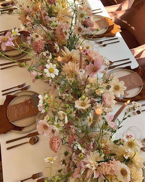 The Table Is Set With Flowers And Place Settings For Guests To Sit Down