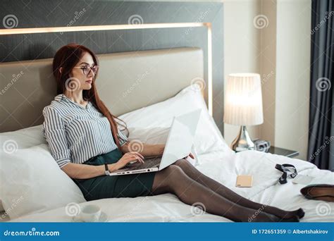 Elegant Woman Lying Dressed On Bed With Laptop At The Hotel Room Stock