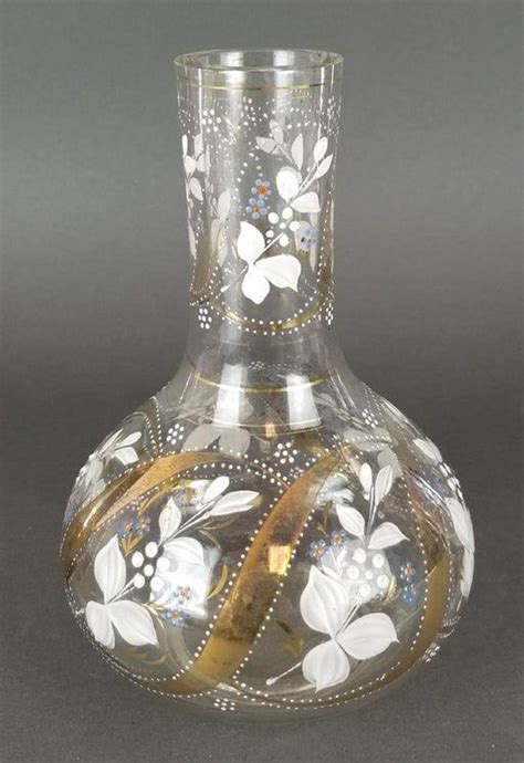 A Glass Vase With Flowers Painted On The Side And Gold Trimming Around The Bottom
