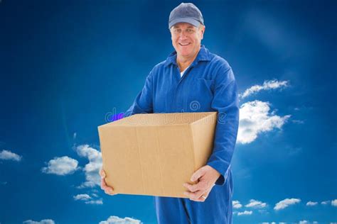 Composite Image Of Happy Delivery Man Holding Cardboard Box Stock Image