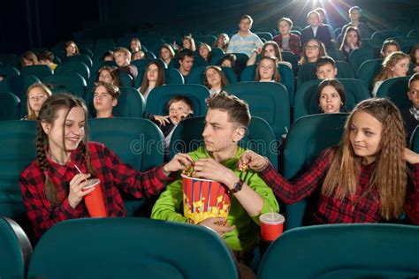 Frontview De Tres Amigos Que Comen Las Palomitas Mirando Película Foto