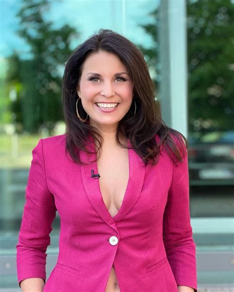 a woman in a pink suit posing for the camera with her hands on her hips