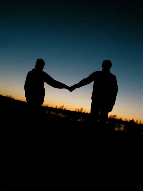 Silhouetted Couple Holding Hands into the Sunset | Couple silhouette ...