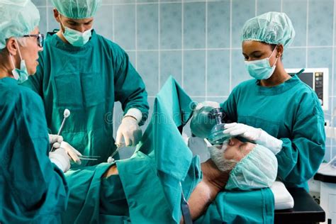 Group Of Surgeon Doctor Team At Work In Operating Room Stock Photo