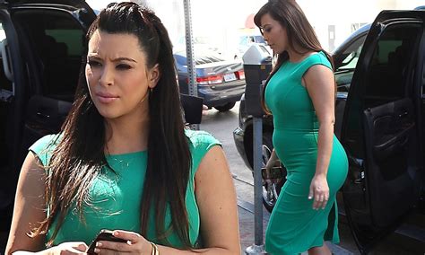 kim kardashian cuts a sombre figure as she steps out tight green dress while kanye west