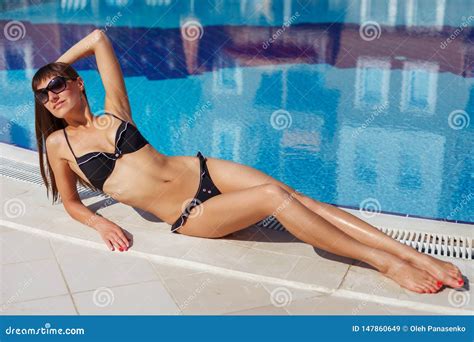 Portrait Of Beautiful Tanned Woman Relaxing In Swimming Pool In Black