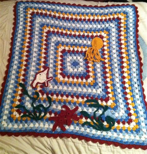 A Crocheted Blanket With An Octopus And Jellyfish Design On The Bottom