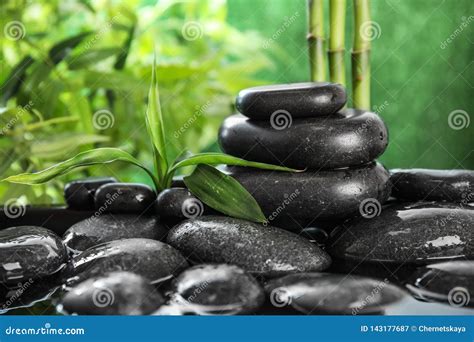 Zen Stones And Bamboo Leaves In Water On Blurred Background Stock Image