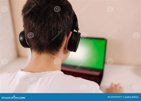 Back View Of Young Boy Play Game On Laptop Green Screen Steamer In