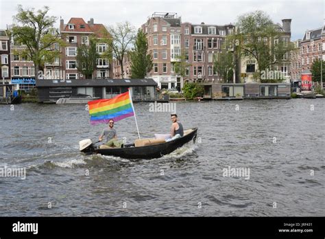 amsterdam the netherlands 5th august 2017 two men flying the rainbow flag from their