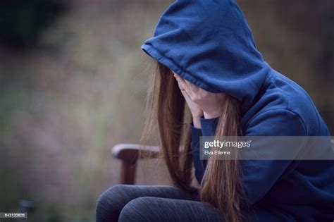 Teenage Girl In Hooded Top With Head In Hands In Despair High Res Stock