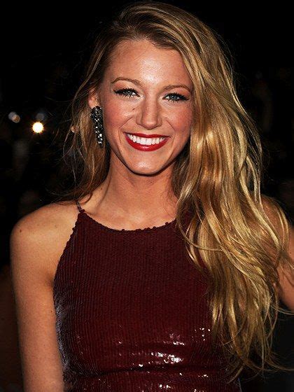 A Woman With Long Blonde Hair Wearing A Red Dress And Smiling At The