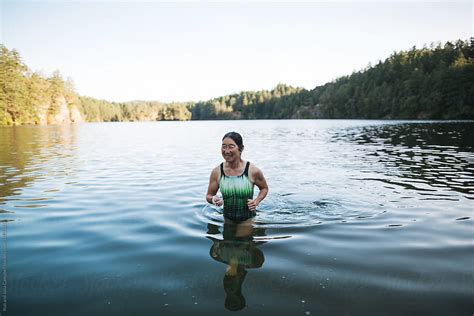 portrait of smiling active woman after swimming in a lake by stocksy contributor rob and