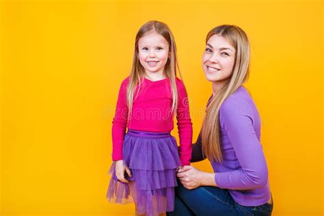 Young Beautiful Mom With Her Daughter Wearing Bright Clothes Posing And