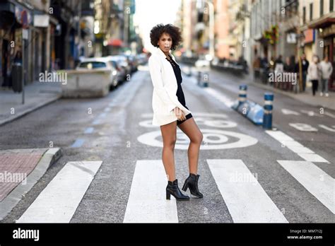 Young Black Woman With Afro Hairstyle Walking On A Crosswalk In An