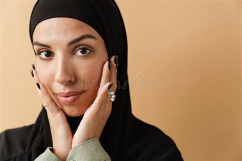 A Portrait Of The Muslim Woman Wearing Black Hijab And Holding Hands Near The Face And Looking